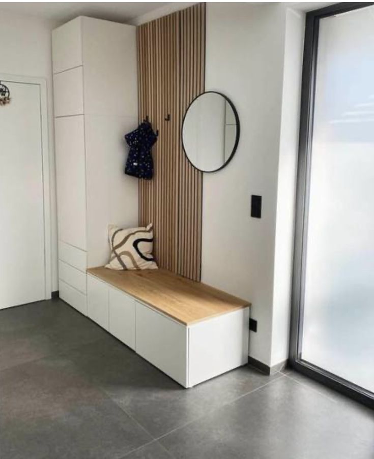 a room with a bench, mirror and coat rack