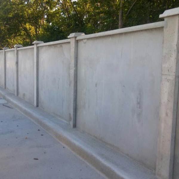 a long concrete fence is lined up along the street