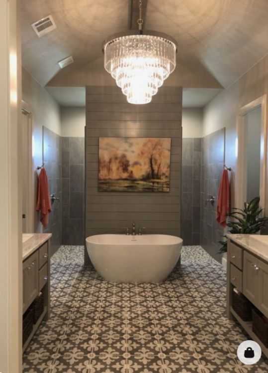 a bath room with a large tub and a chandelier hanging from the ceiling