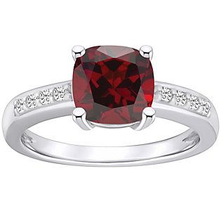 a red diamond ring with white diamonds on the band and an oval cut stone in the center