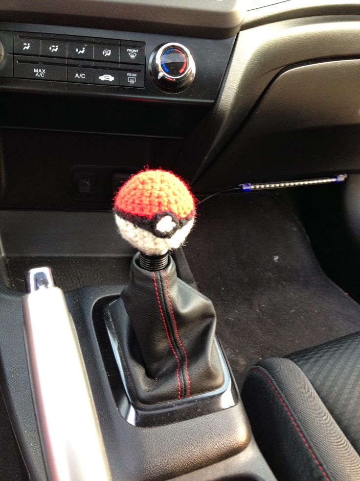 the interior of a car with a small stuffed animal in it's center console