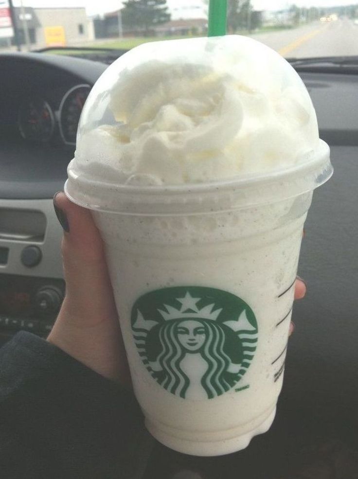 someone is holding up a starbucks drink in their hand with whipped cream on the top