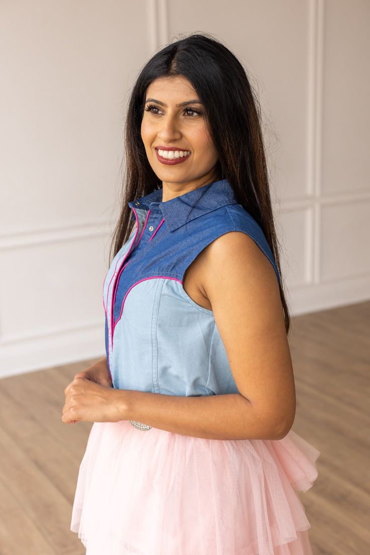 This Western-inspired piece seamlessly blends sweet southern charm with a touch of sophistication. The classic pearl snaps and sleeveless design makes this the perfect top to keep you cool in the Summer months. Embrace the cool cowgirl vibes this Summer with your new favorite top. Material: 100% CottonFit: RelaxedOur model is wearing a size small Western Style Collared Tops For Summer, Western Collared Tops For Summer, Western Collared Summer Tops, Western Style Blue Tops For Spring, Western Style Sleeveless Tops For Spring, Sleeveless Western Tops For Spring, Fitted Western Tops For Summer, Fitted Tops For Rodeo In Summer, Fitted Sleeveless Top For Rodeo