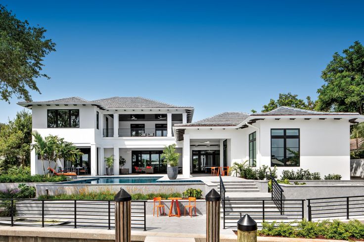 a large white house with a pool in the front yard and fenced in area