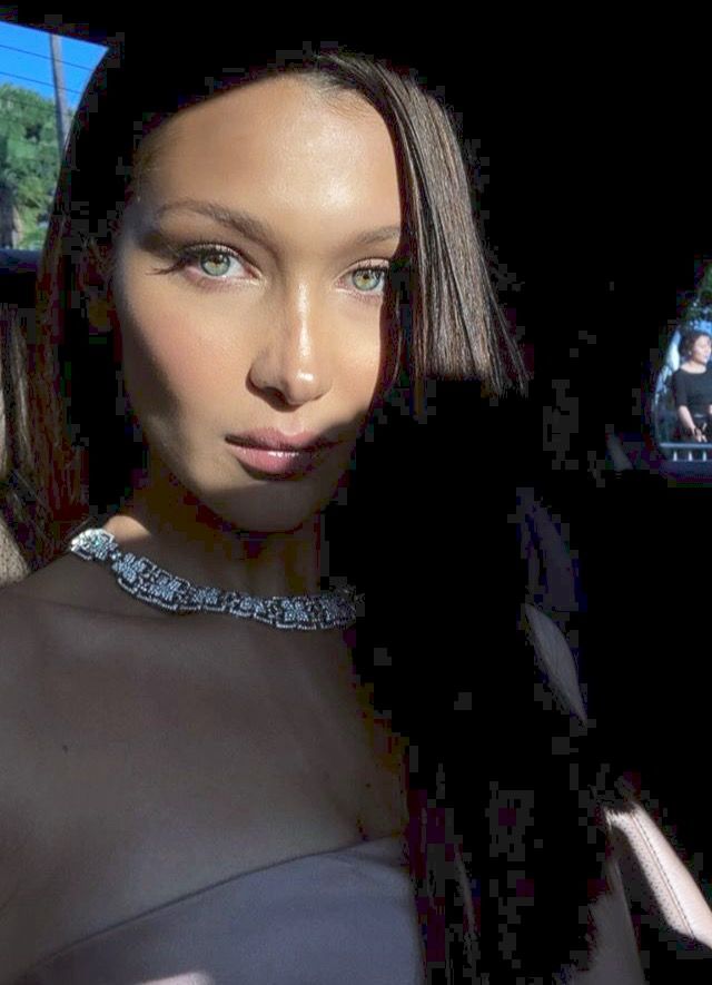 a woman sitting in the back seat of a car with her hand on her hip