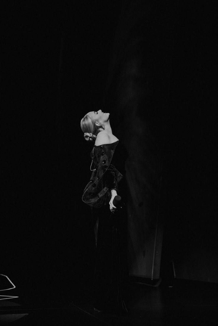 black and white photograph of a woman standing in the dark