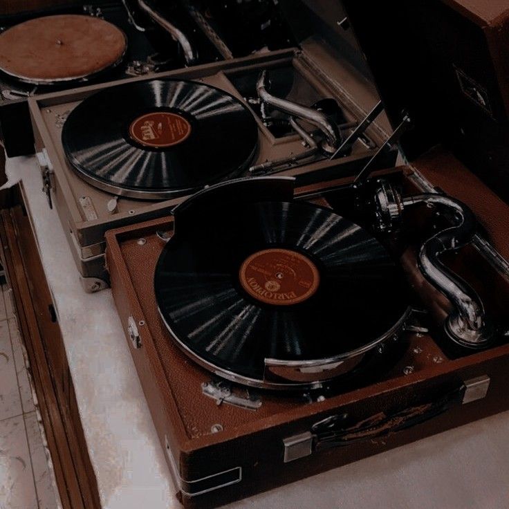 two turntables sitting next to each other on top of a wooden box with metal handles