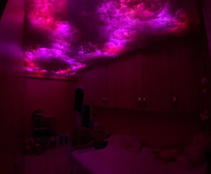 a bedroom with purple clouds in the ceiling and pink lighting on the wall above it