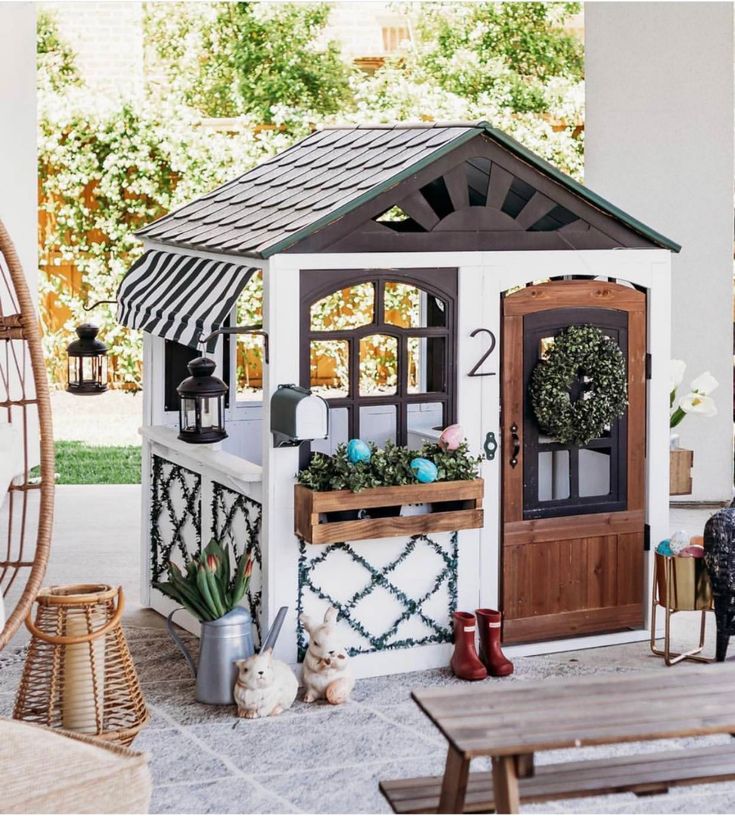 a doll house with furniture and decorations on the front porch, including a patio table