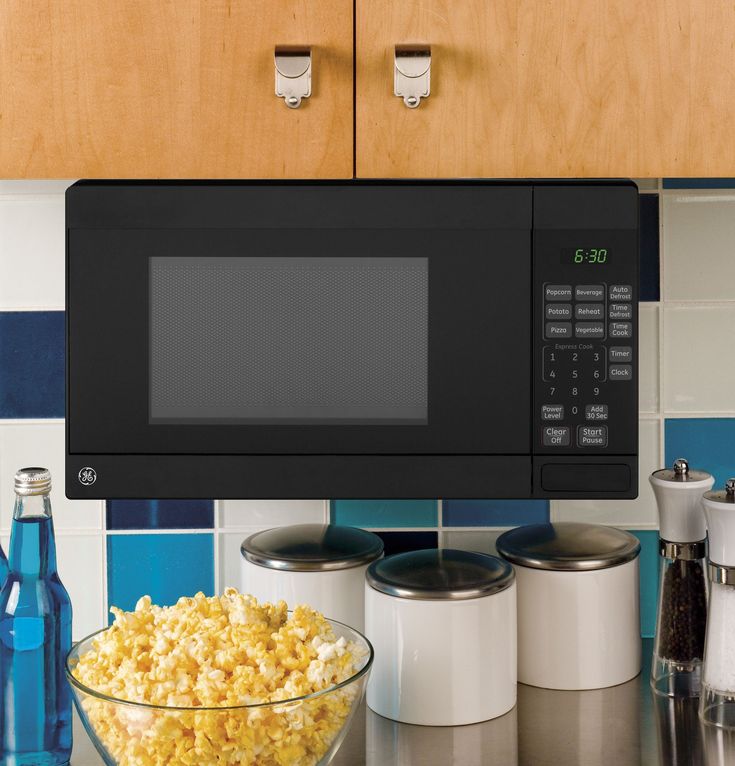 a microwave oven over a bowl of popcorn