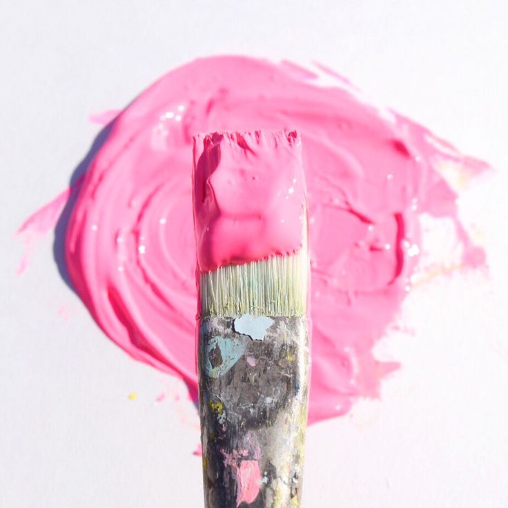 a close up of a paintbrush with pink paints on it