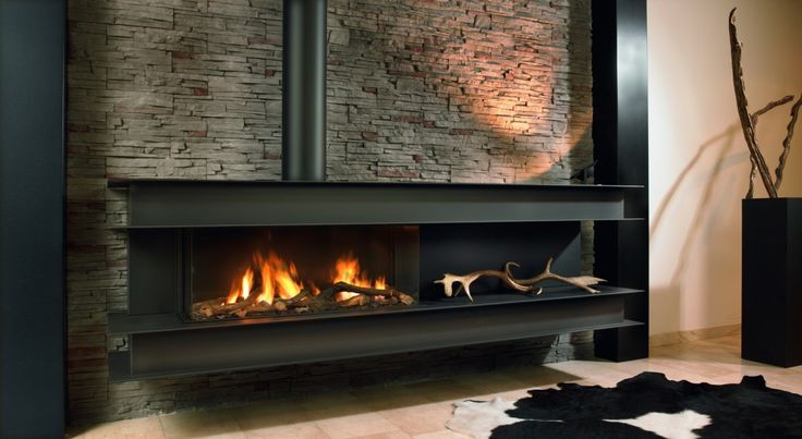 a fire place in a living room next to a brick wall with a fireplace on it