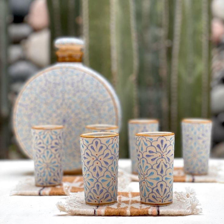 a table topped with blue and white cups