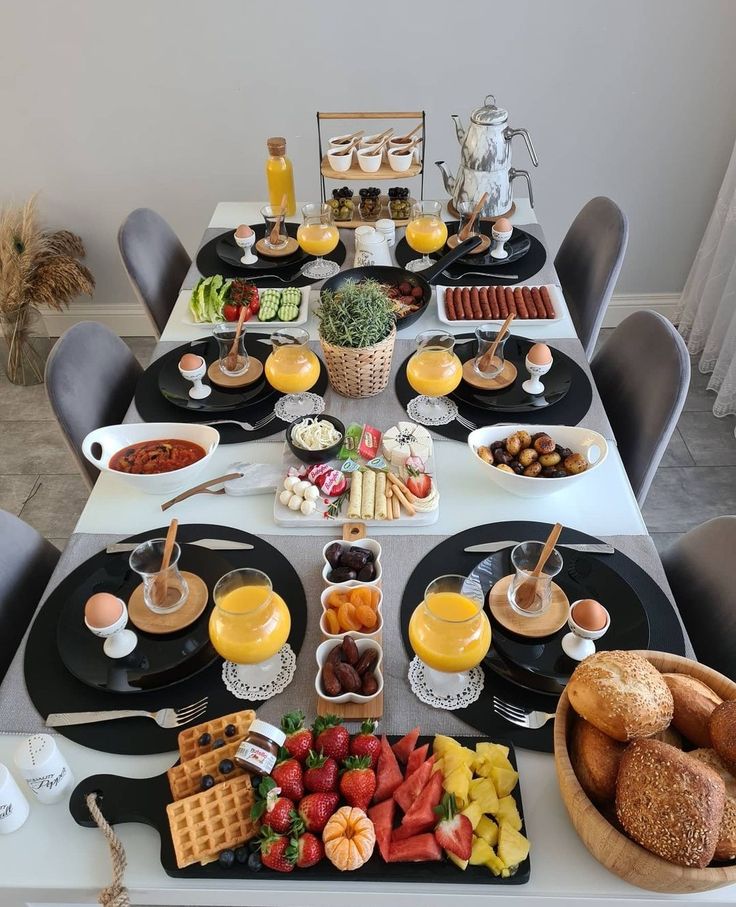 a table filled with breakfast foods and drinks on it's sides, along with other food items