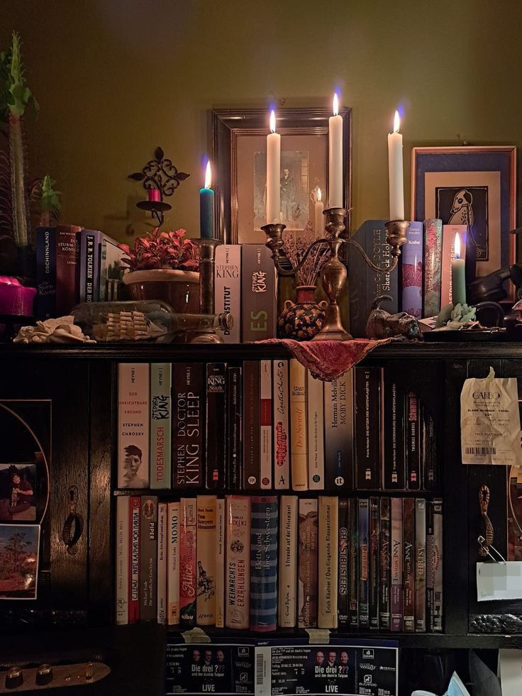 a book shelf filled with books and candles