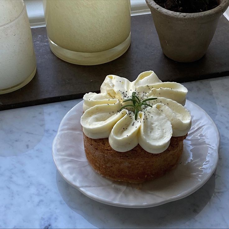 there is a cake with bananas on it sitting on a plate next to a potted plant