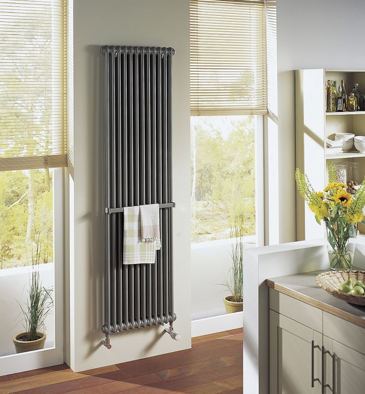 a radiator in the middle of a kitchen next to a sink and window