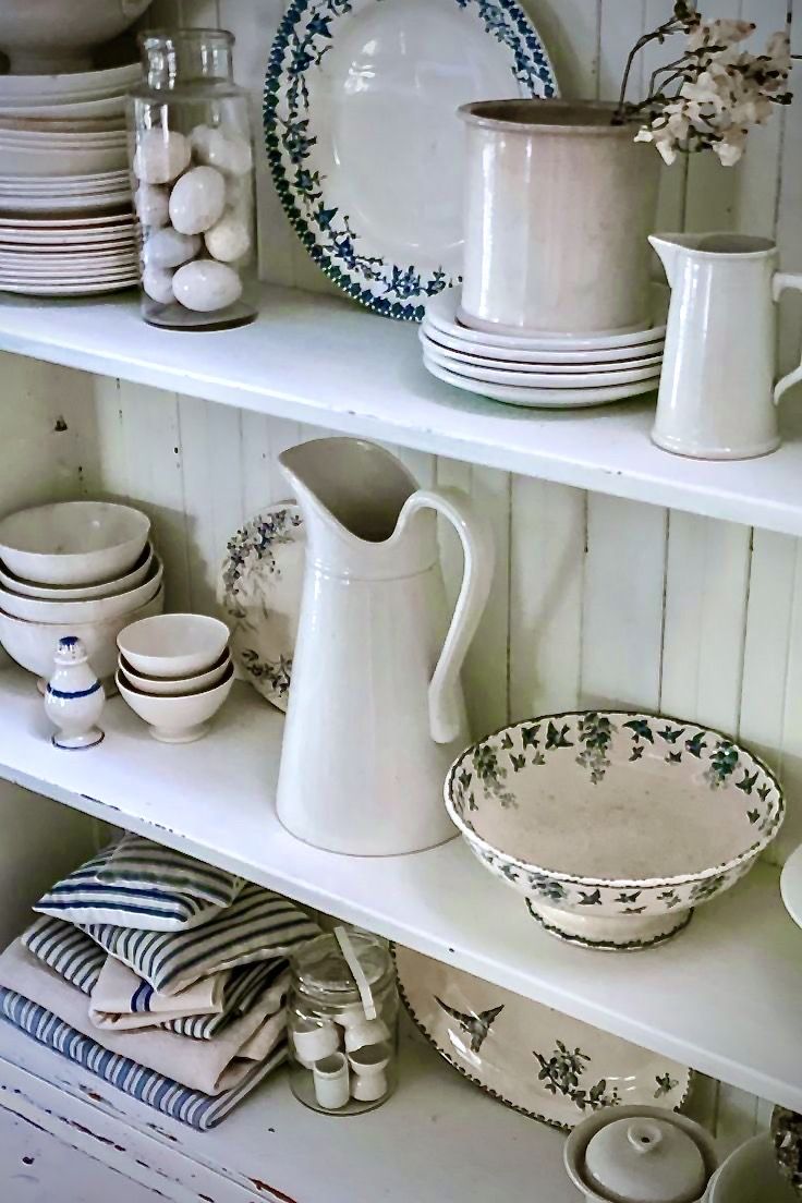 the shelves are filled with dishes and vases