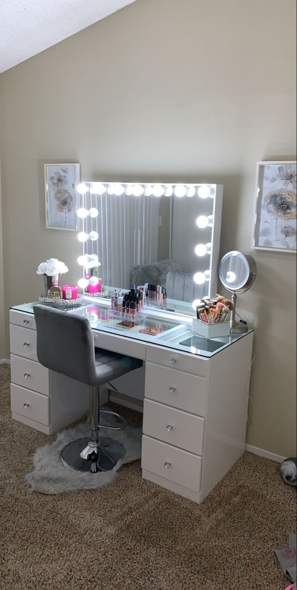 a desk with a chair, mirror and lights on it