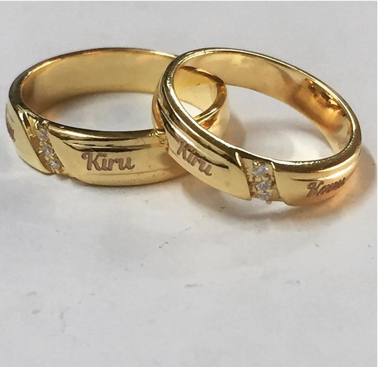 two yellow gold wedding rings with diamonds on each one and the word love written in cursive writing