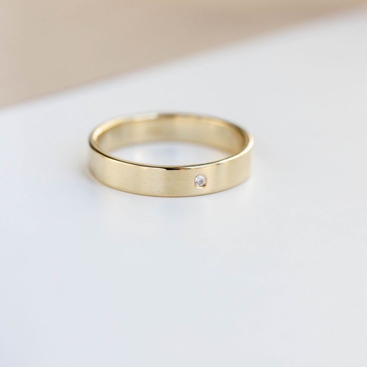 Wedding Band Women, Gold Wedding Ring, Diamond Wedding Band, Simple Wedding Ring, Flat Wedding Band, Eco Wedding Band, Simple Band A classic ring made of K14 solid gold with a tiny diamond with softened edges for comfort. Engrave the ring with no extra cost. High polished wedding band 100% handcrafted. D E T A I L S ● Metal: 14K Solid Gold, 14K White Gold, 14K Rose Gold ● Gemstone: Clear diamond, 0.01ct 1.3mm, VS - G ● Finish: High polished or mate ● Dimensions: 3.7mm width, 1.2 thickness R I N Diamond Jewelry With Smooth Bezel For Wedding, Wedding Jewelry With Smooth Bezel Diamond, Simple Round Band Diamond Anniversary Ring, Simple Gold Diamond Ring For Anniversary, Classic Wedding Diamond Ring With Smooth Bezel, Minimalist Wedding Rings With Smooth Bezel, 14k Gold Single Diamond Wedding Ring For Anniversary, Yellow Gold Single Diamond Ring For Anniversary, 14k Gold Bridal Jewelry With Single Diamond For Anniversary