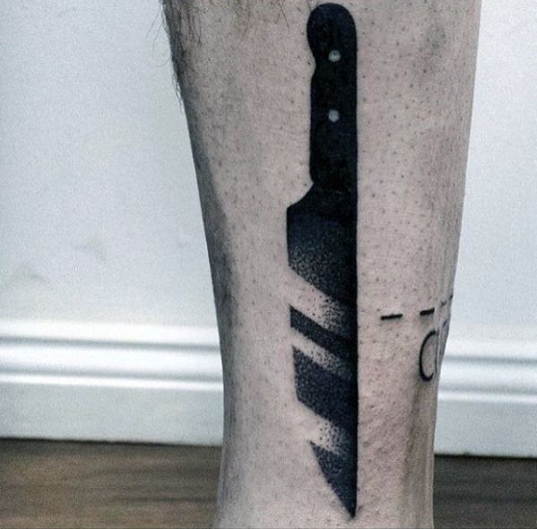 a man's leg with a knife tattoo on it