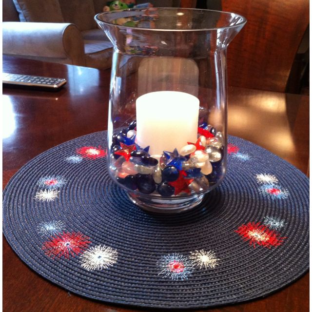 a candle is lit in a glass vase on a placemat with stars and beads