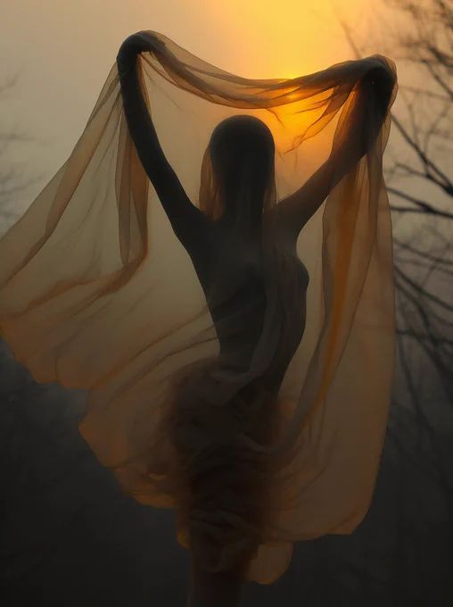 a woman is standing in front of the sun with her hands on her hips and wearing a sheer shawl