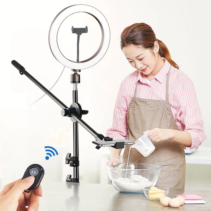 a woman is mixing something in a bowl on a table with a camera and an antenna