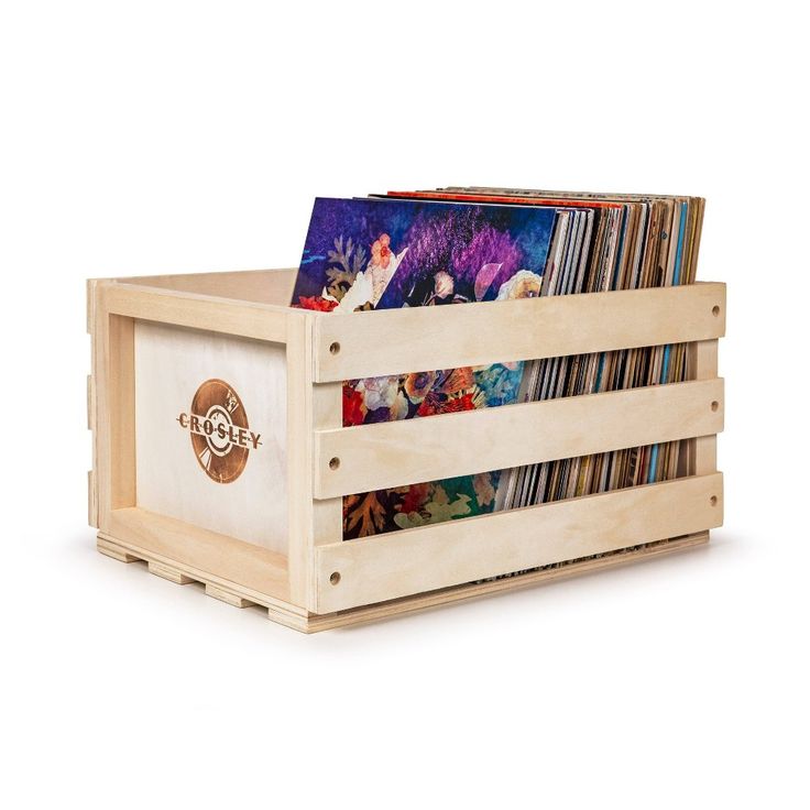 a wooden box with cd's in it sitting on a white surface next to a pile of cds