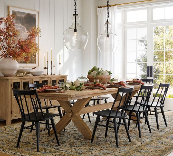 a dining room table with chairs and plates on it