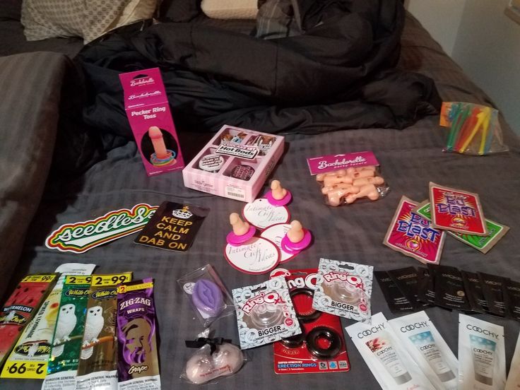 the contents of an unmade bed spread out neatly on top of it, including candy and other items