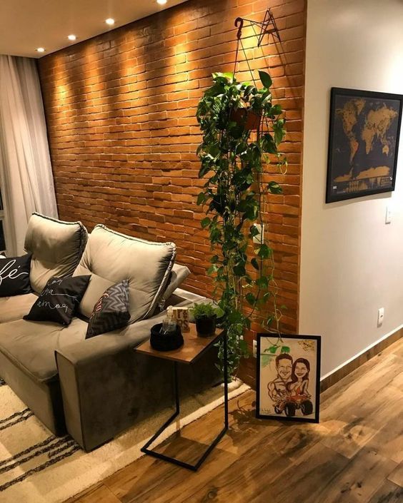 a living room filled with furniture and a plant in front of a wall mounted tv