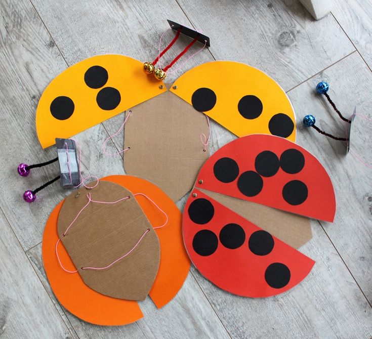 four paper ladybugs are laid out on the floor