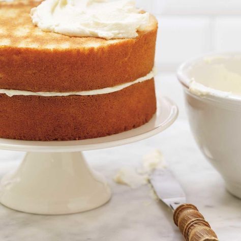 a cake sitting on top of a white plate next to a bowl of whipped cream