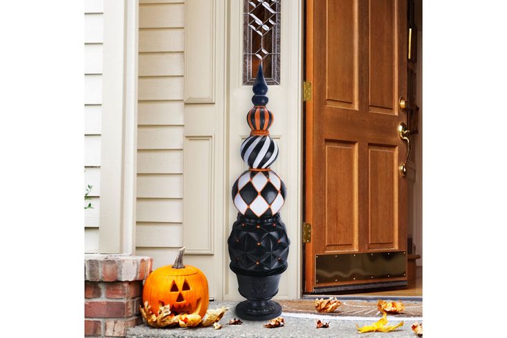 an outdoor halloween decoration with pumpkins and jack - o'- lanternes on the front porch