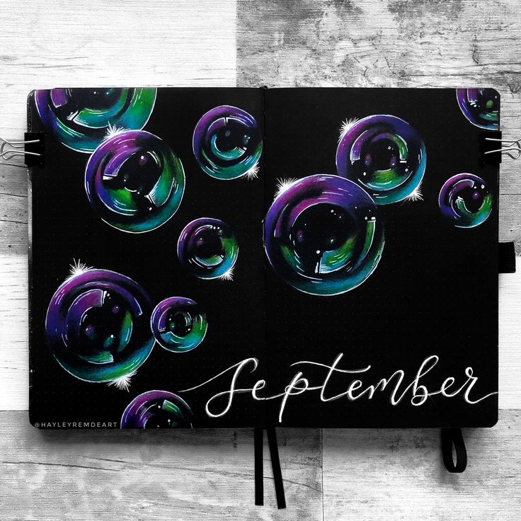 an open notebook with soap bubbles on it and the words september written in cursive writing