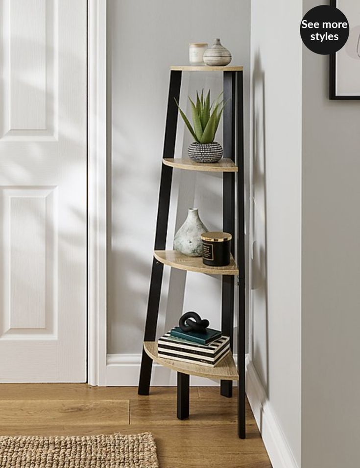 a three tiered shelf in the corner of a room next to a door with a potted plant on top