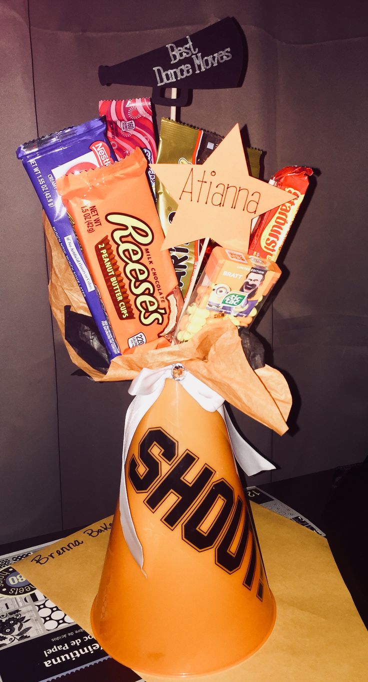 an orange bucket filled with assorted candy and candies sitting on top of a table