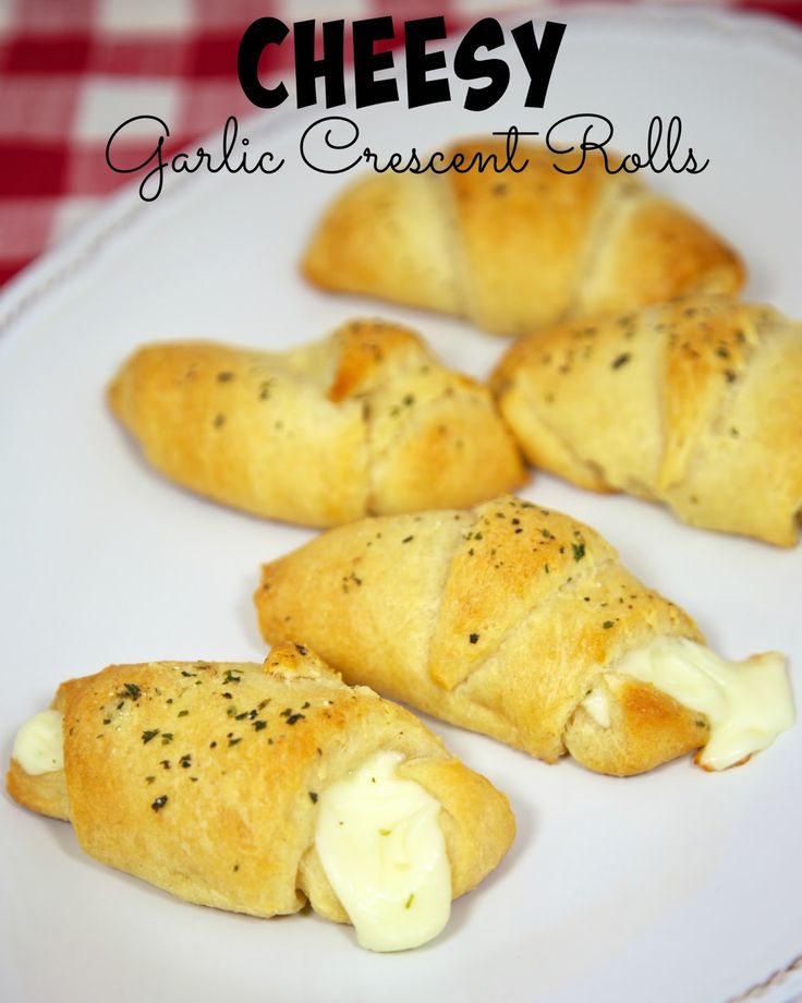 four cheesy garlic crescent rolls on a white plate