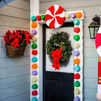 a christmas door decoration with candy canes and wreath