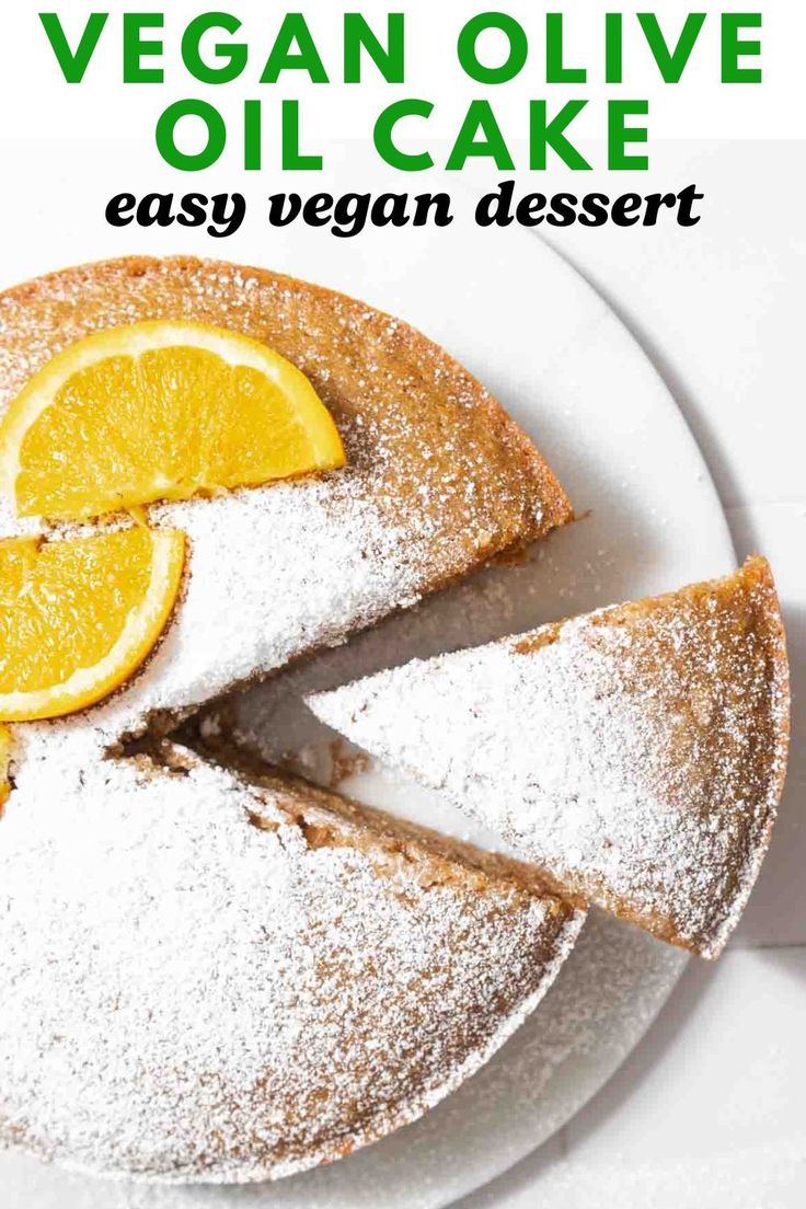 vegan olive oil cake on a white plate with lemons and powdered sugar