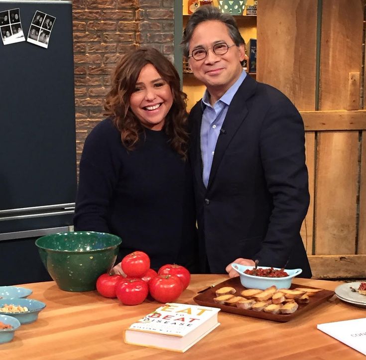 a man and woman standing in front of a table with food on top of it