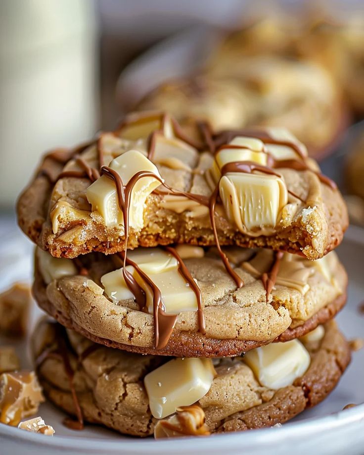 three cookies stacked on top of each other with chocolate drizzled on them