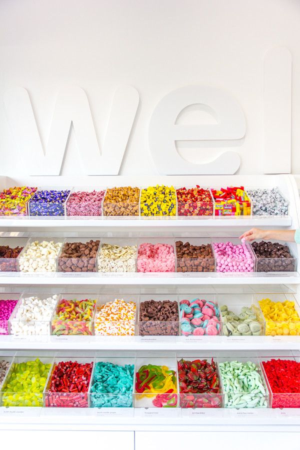 a display case filled with lots of different types of candies and chocolates on top of white shelves