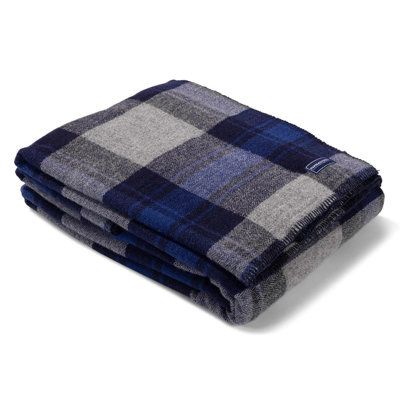 the blue and grey plaid blanket is folded on top of each other