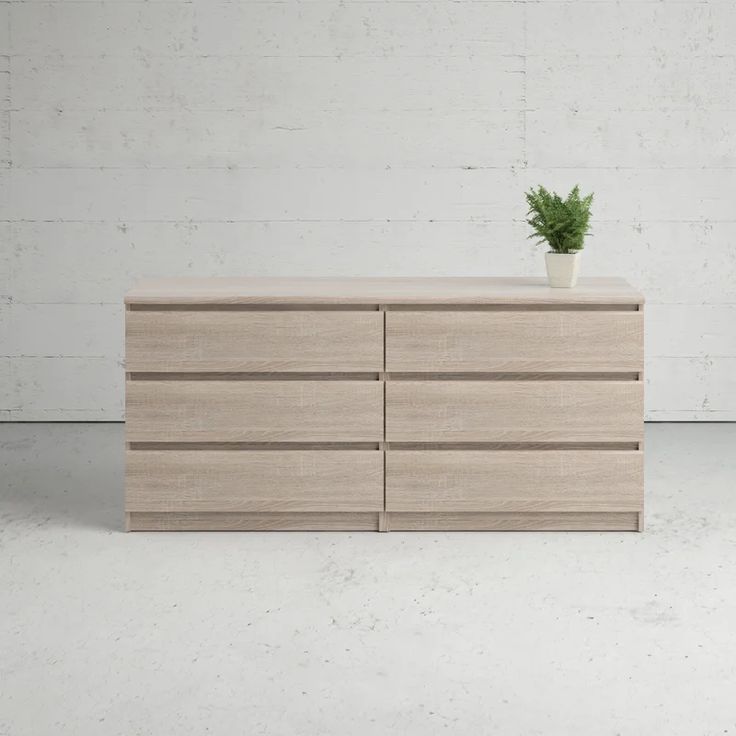 a wooden dresser with a potted plant on top