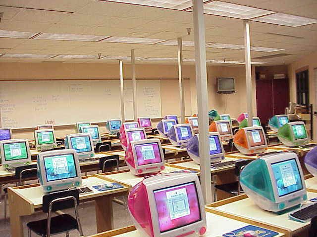 rows of desks with computers on them in a classroom