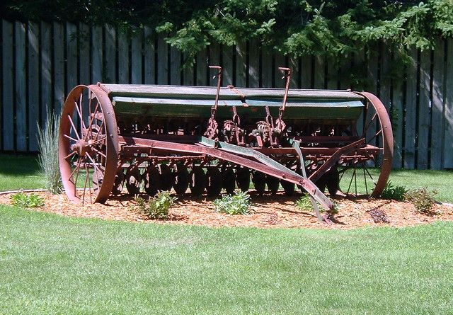 an old farm equipment sitting in the grass