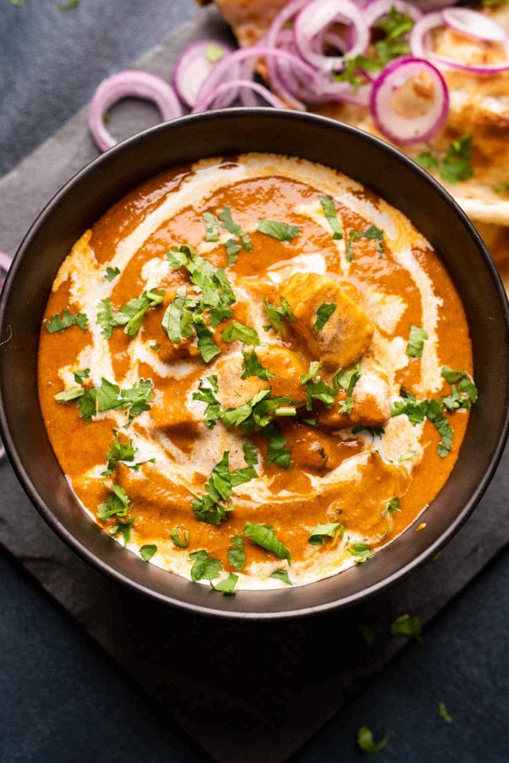 a bowl filled with food and garnished with cilantro, onions and cheese